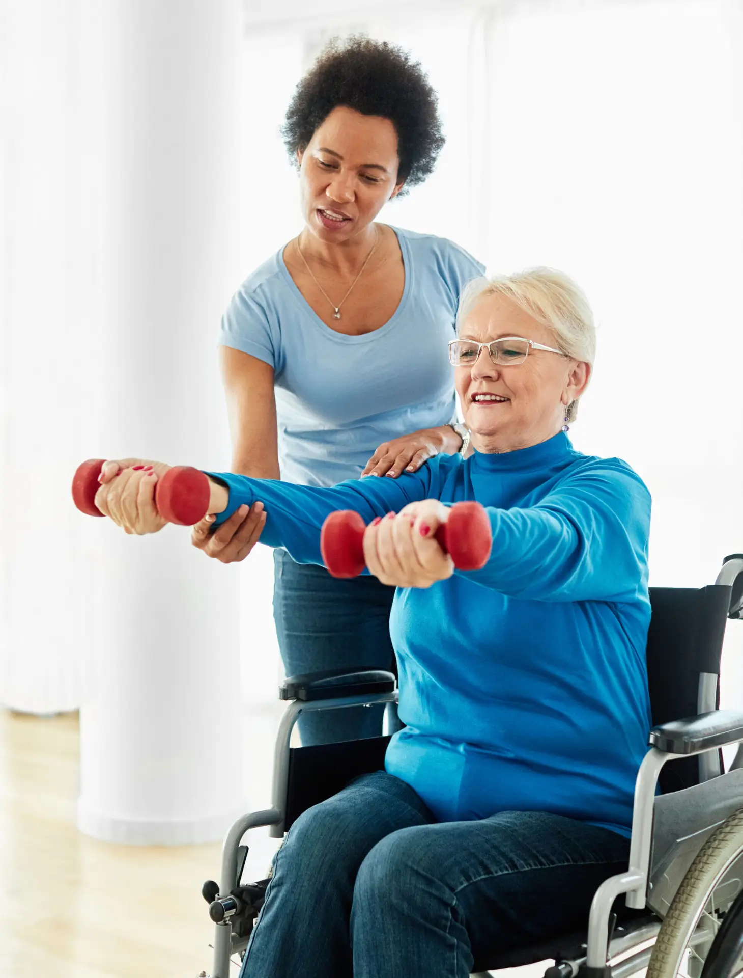 Elderly woman receiving assisted stretching with a resistance band during a physiotherapy session