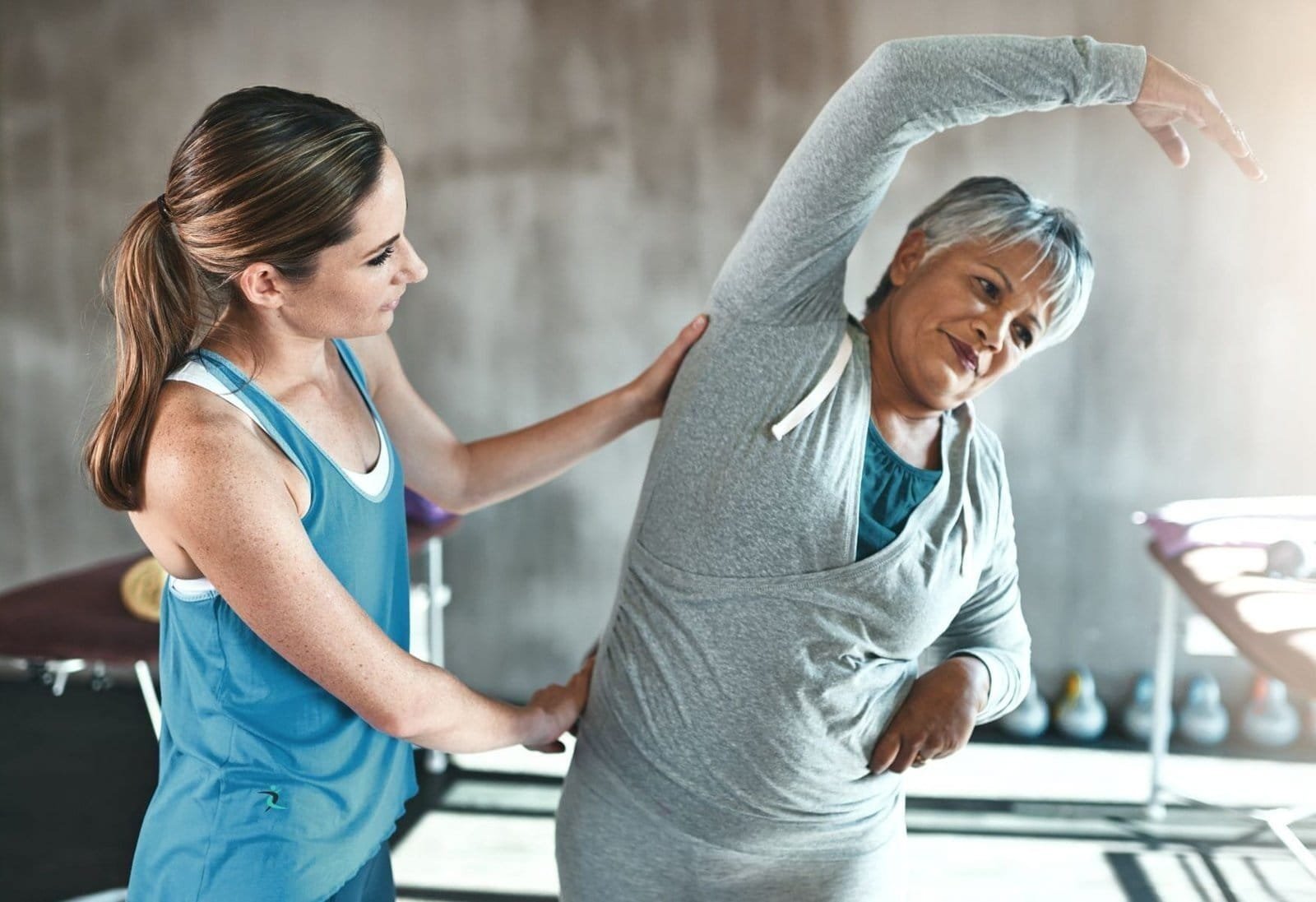 Senior woman doing home exercises with trainer