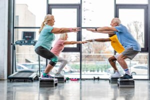 Senior woman doing gentle stretches at home with a personal trainer