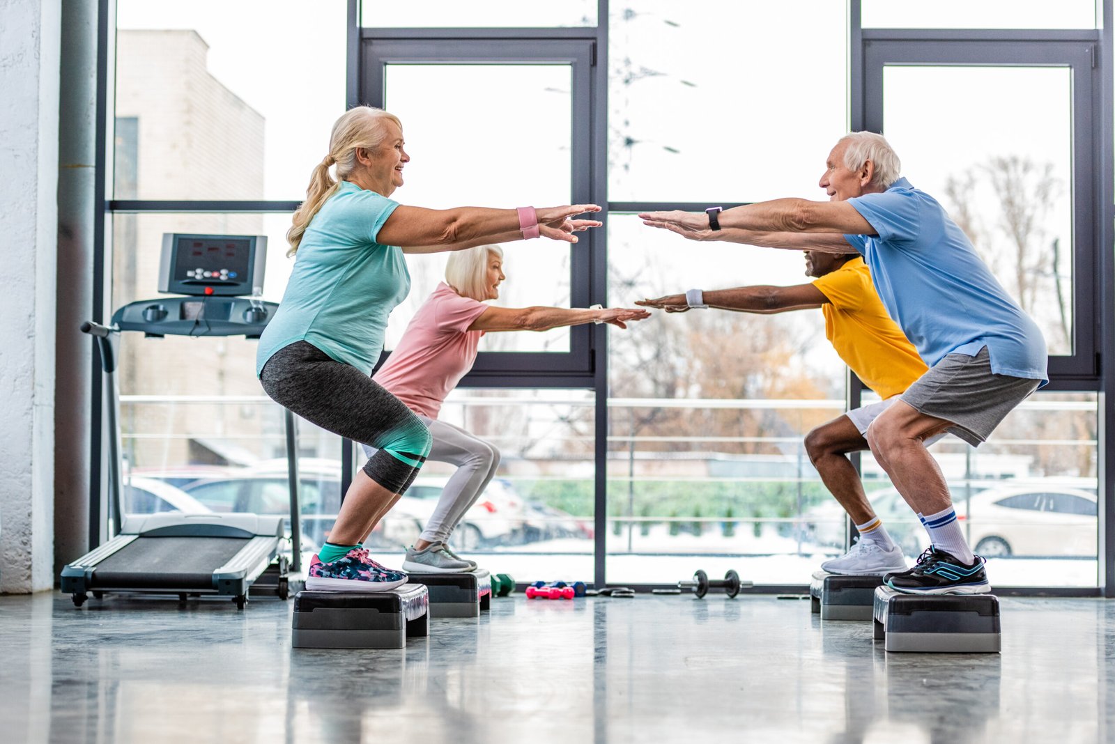 Senior woman doing gentle stretches at home with a personal trainer