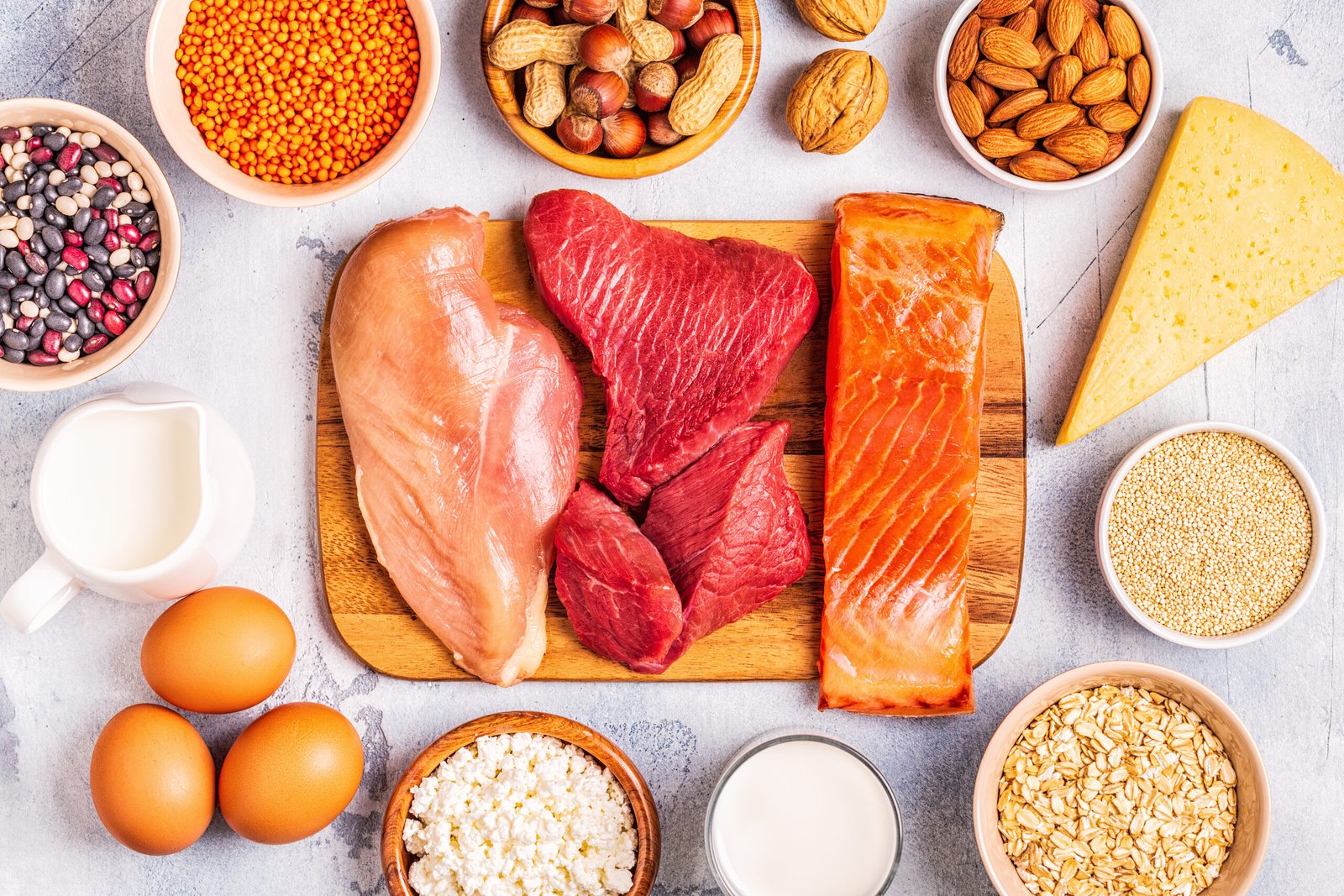 A variety of protein-rich foods including fish, chicken, beef, eggs, dairy, nuts, and grains