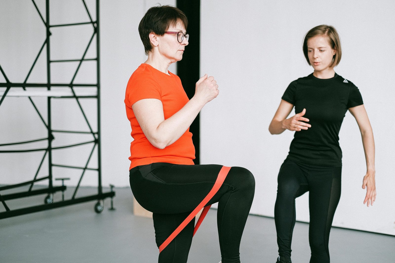The Ultimate Guide to Senior Fitness in Mississauga (Your 2025 Summer Guide) 2 An Ember Fitness coach guiding a senior client through a resistance band exercise in the comfort of her Mississauga living room