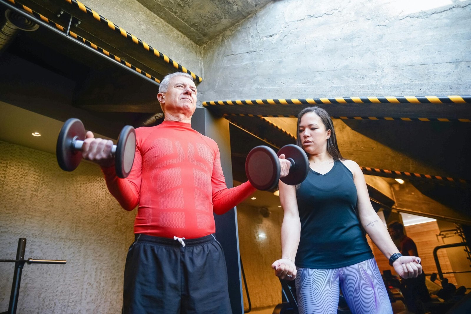 An empowered senior man in Mississauga safely performing a bicep curl with a dumbbell, demonstrating that building strength after 60 is achievable.