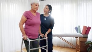 Senior woman exercising with resistance bands under the guidance of a personal trainer at home