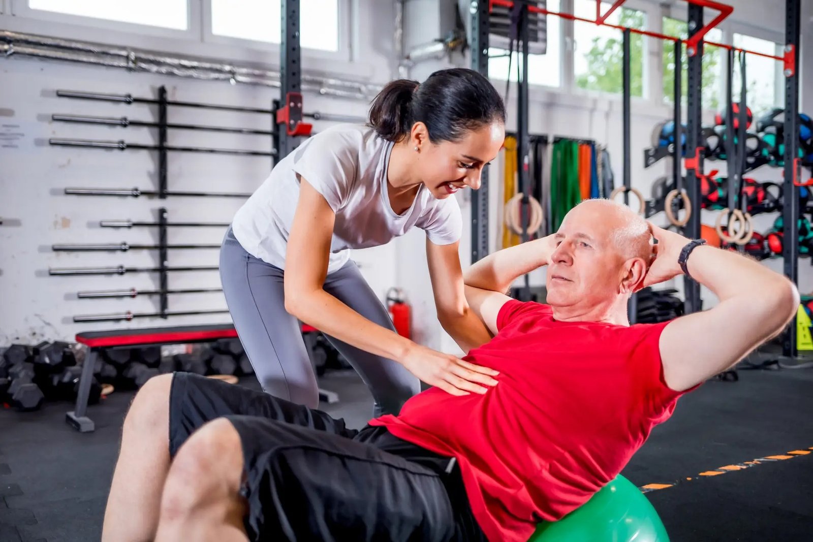 Personal trainer in Toronto for seniors. helping a senior man with safe in-home fitness training