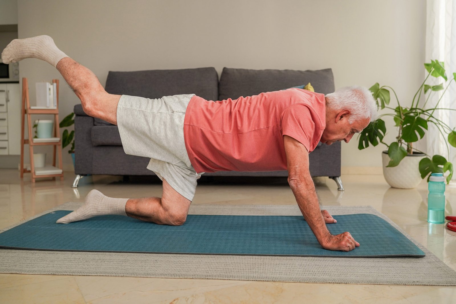 senior practicing balance exercises with personal trainer at home