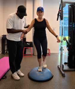 senior performing single leg stance balance exercise on BOSU ball