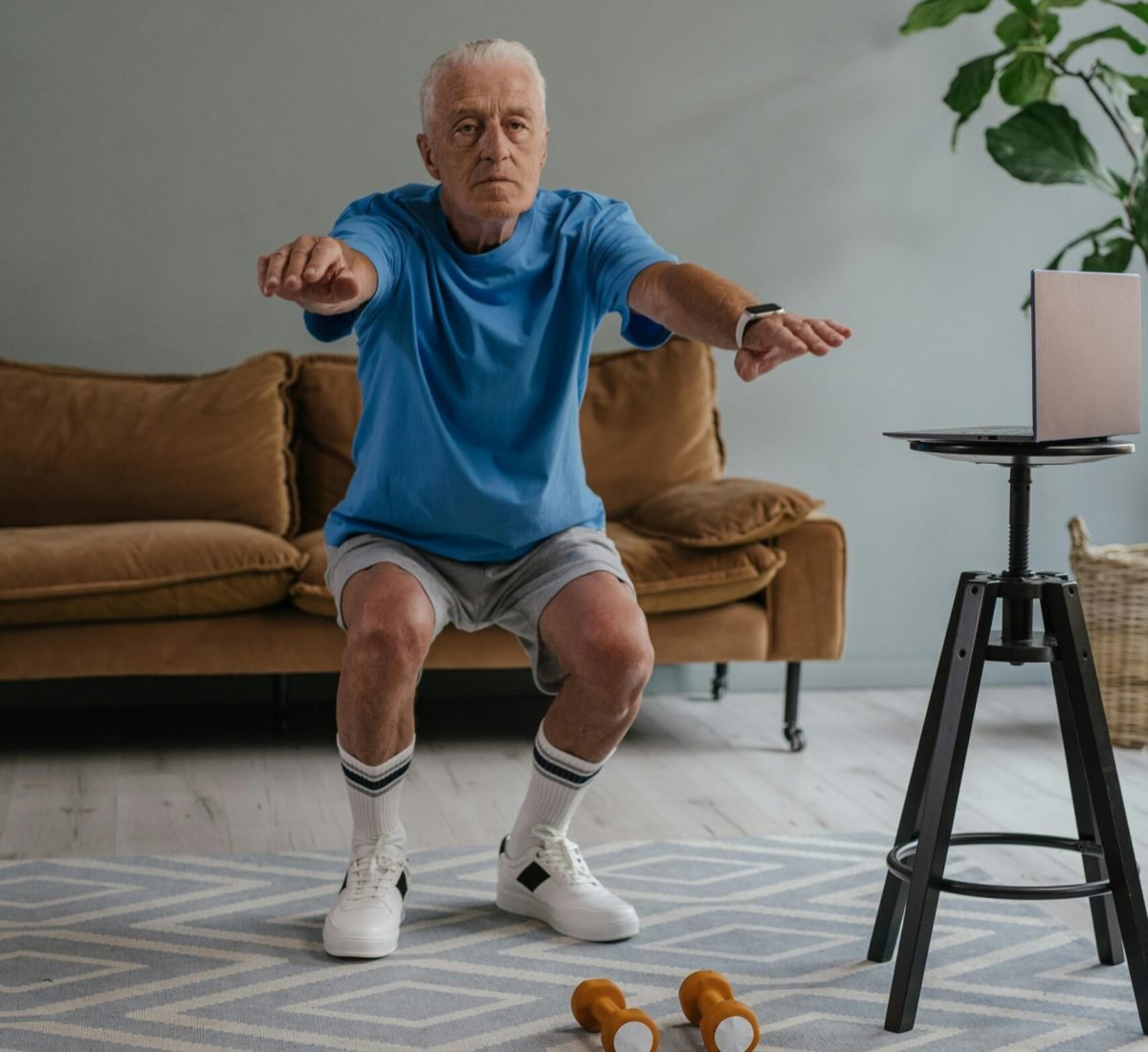 Senior woman practicing balance and mobility exercises with trainer in Oakville living room