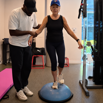 senior performing single leg stance balance exercise on BOSU ball